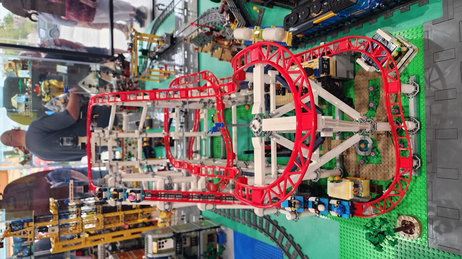 The red roller coaster winds through the LEGO city