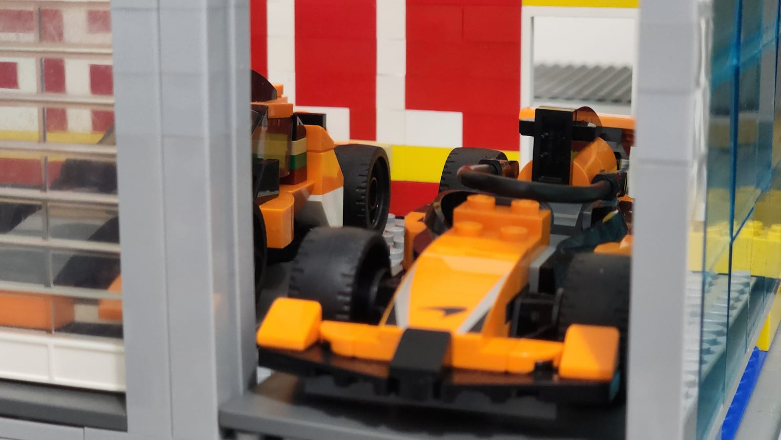 Close-up of the IMS Pagoda LEGO pace car garage showing the McLaren F1 pace car inside with manual garage doors